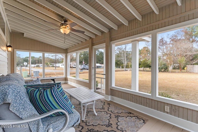 unfurnished sunroom with a ceiling fan and vaulted ceiling with beams