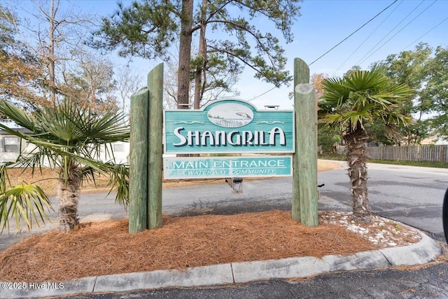 community / neighborhood sign featuring fence