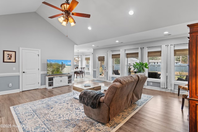 living room with baseboards, high vaulted ceiling, wood finished floors, and recessed lighting