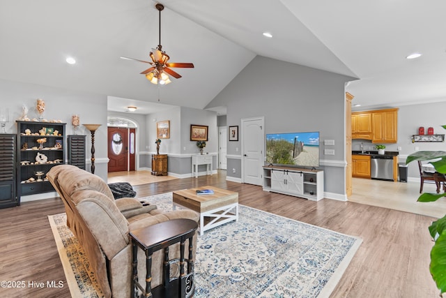 living area featuring high vaulted ceiling, baseboards, ceiling fan, and light wood finished floors