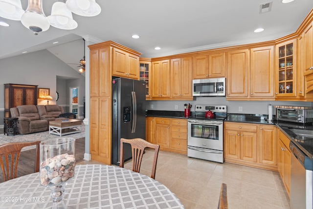 kitchen featuring stainless steel appliances, visible vents, open floor plan, glass insert cabinets, and pendant lighting