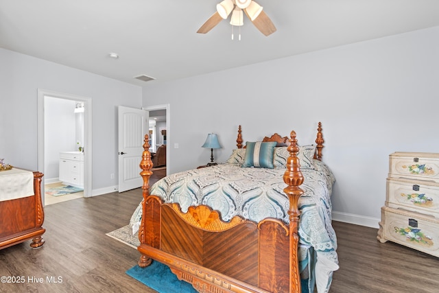 bedroom featuring ensuite bathroom, dark wood finished floors, visible vents, and baseboards