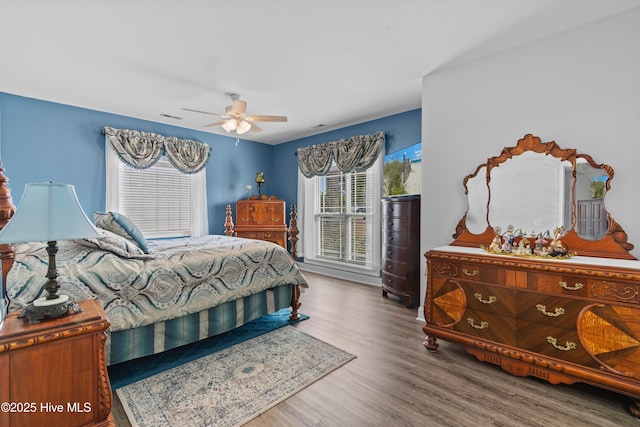 bedroom with visible vents, ceiling fan, and wood finished floors