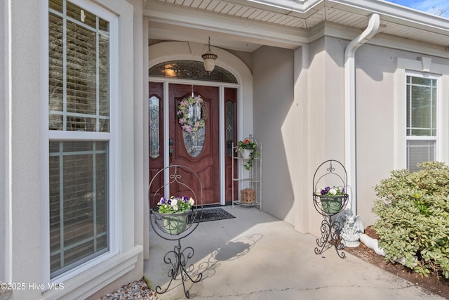 entrance to property featuring stucco siding