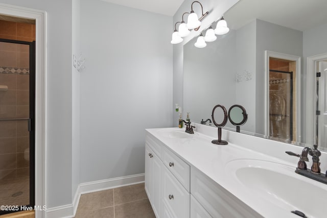 bathroom with double vanity, a sink, baseboards, and tile patterned floors