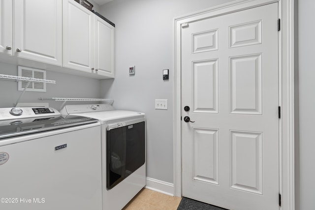 laundry area featuring light tile patterned floors, independent washer and dryer, cabinet space, and baseboards