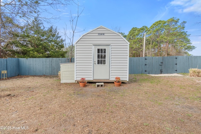 view of shed with a fenced backyard and a gate