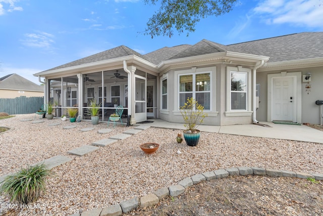 back of house with roof with shingles, a patio, a ceiling fan, a sunroom, and fence