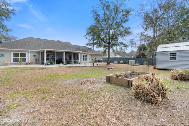 back of house with a sunroom, a garden, fence, and a yard