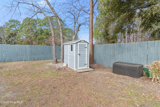 view of yard featuring a fenced backyard, an outdoor structure, and a shed