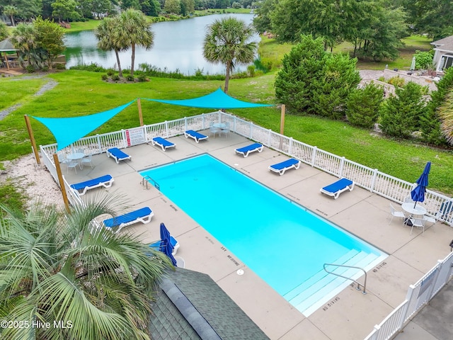 community pool featuring a patio area, a yard, a water view, and fence