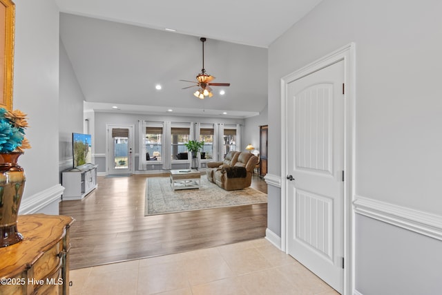 living area featuring light tile patterned floors, baseboards, a ceiling fan, and recessed lighting