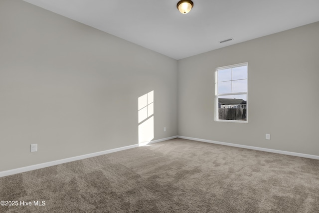 empty room with carpet floors, visible vents, and baseboards