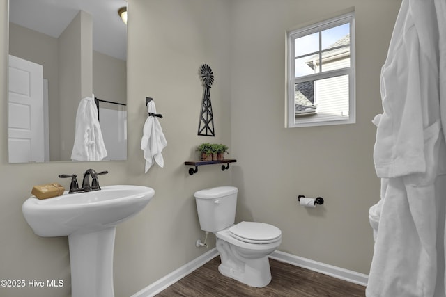 bathroom with a sink, wood finished floors, toilet, and baseboards