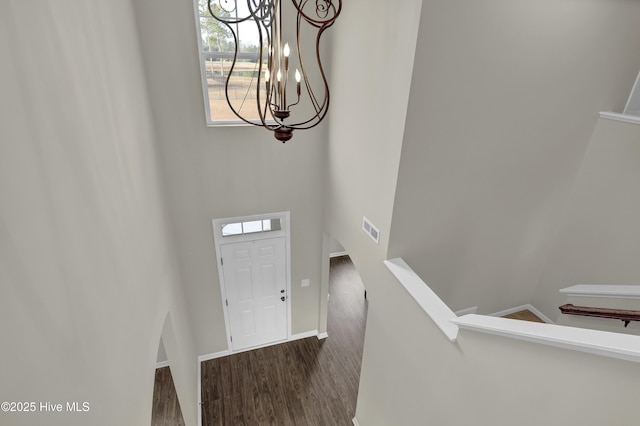 foyer featuring baseboards, visible vents, and wood finished floors