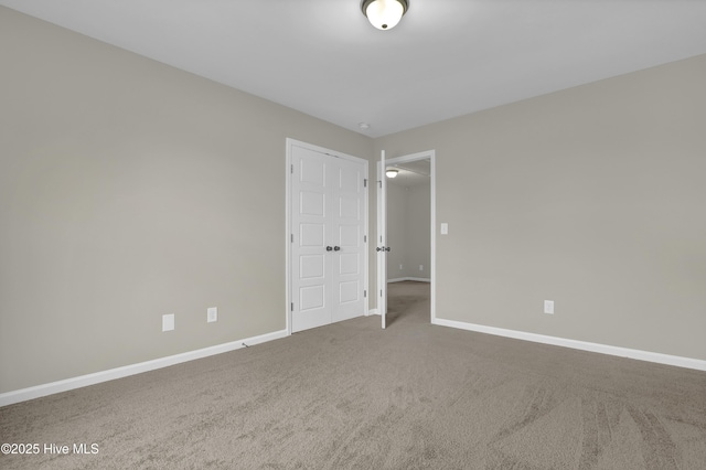 empty room featuring carpet flooring and baseboards