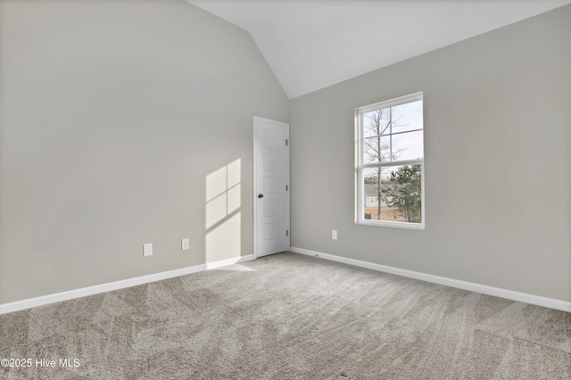 spare room with high vaulted ceiling, carpet, and baseboards