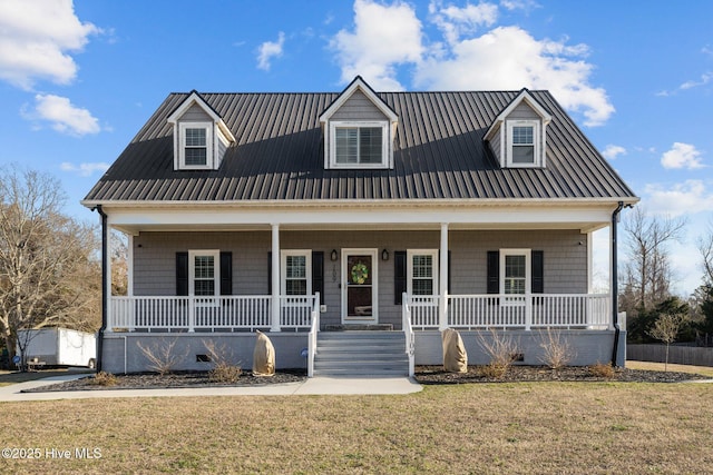 new england style home featuring covered porch, metal roof, and a front yard