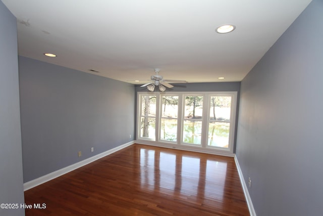 empty room featuring recessed lighting, baseboards, and wood finished floors