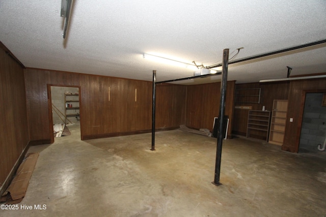 finished below grade area with a textured ceiling and wooden walls