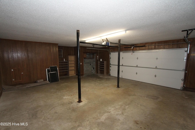 garage with wood walls and a garage door opener