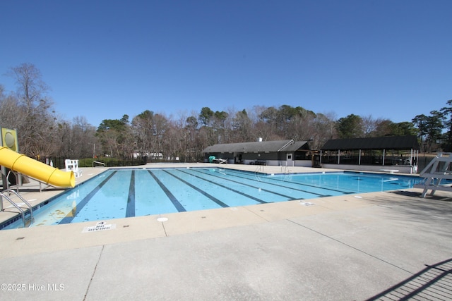 pool with a patio and a water slide