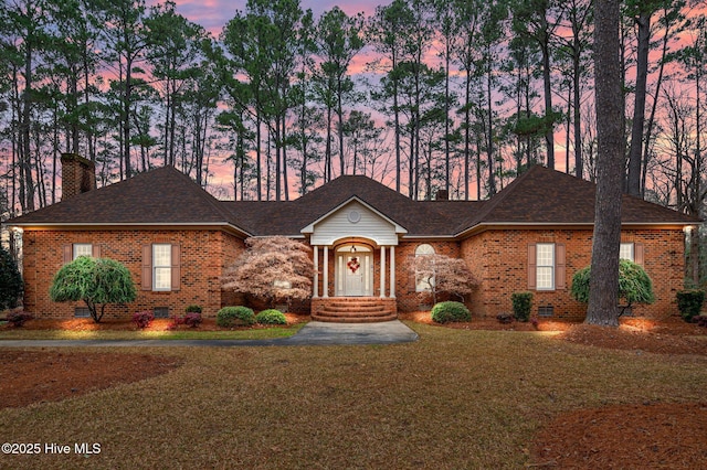 ranch-style house featuring crawl space, brick siding, and a chimney