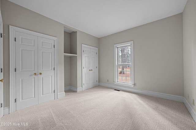 unfurnished bedroom featuring carpet, visible vents, and baseboards