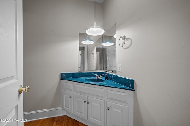 bathroom featuring wood finished floors, vanity, and baseboards