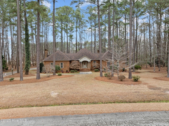 view of front of house with driveway and brick siding