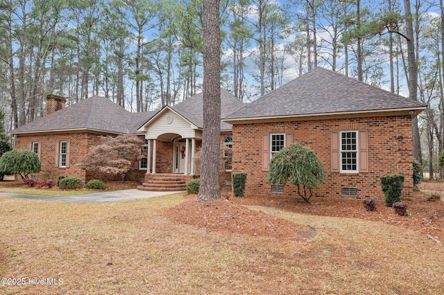 view of front of home with crawl space, brick siding, a chimney, and a shingled roof