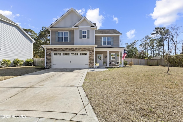 craftsman-style house featuring a porch, fence, driveway, stone siding, and a front yard