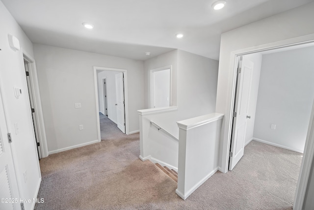 corridor with an upstairs landing, recessed lighting, baseboards, and light colored carpet