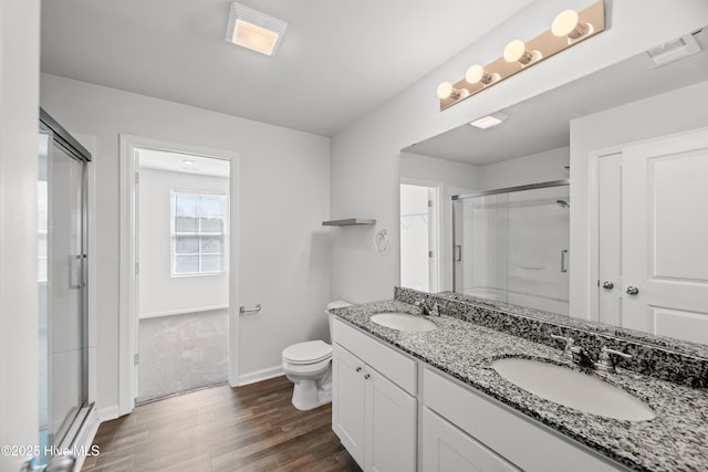 bathroom with a shower stall, baseboards, a sink, and wood finished floors