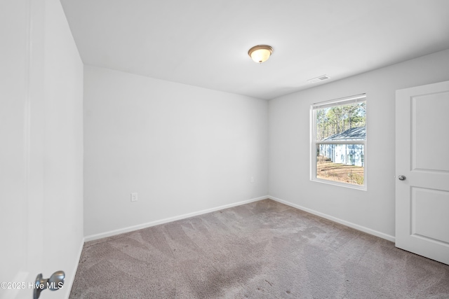 unfurnished room with baseboards and light colored carpet