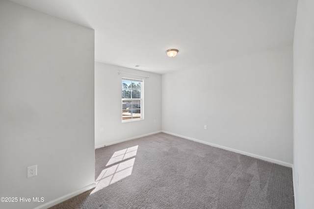 unfurnished room with carpet and baseboards