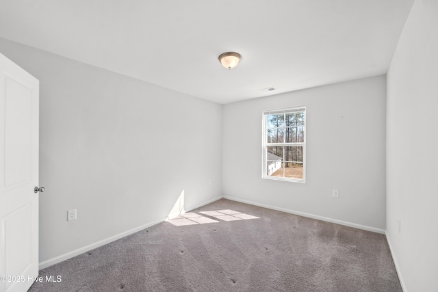 spare room featuring baseboards, visible vents, and carpet flooring