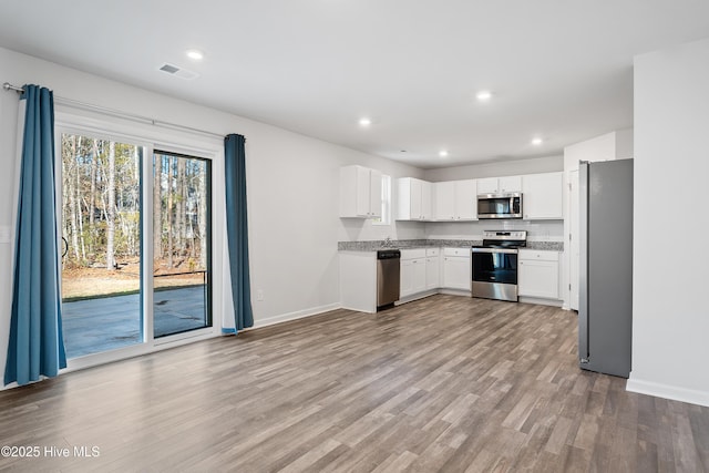 kitchen with visible vents, light wood-style flooring, appliances with stainless steel finishes, white cabinetry, and recessed lighting