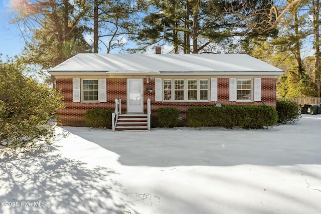 single story home featuring brick siding