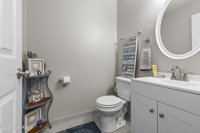 bathroom with toilet, vanity, baseboards, and tile patterned floors