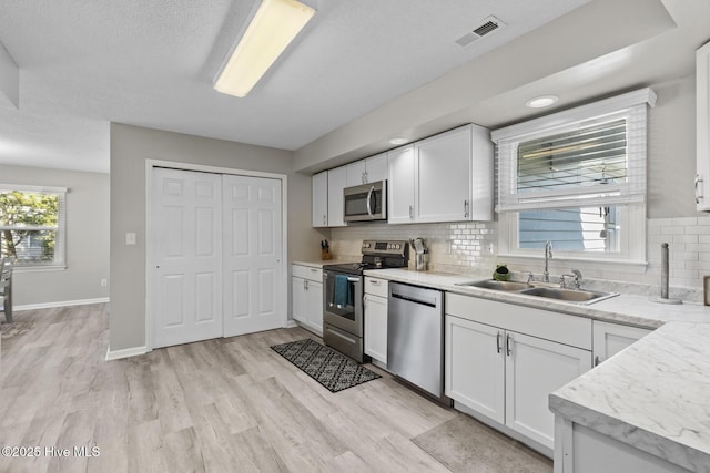 kitchen featuring stainless steel appliances, light countertops, visible vents, and white cabinetry