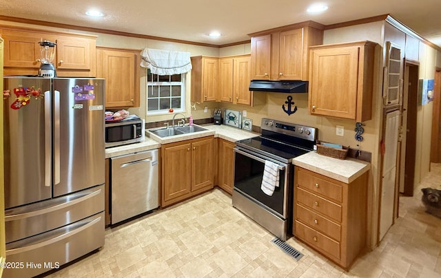 kitchen with under cabinet range hood, a sink, light countertops, appliances with stainless steel finishes, and crown molding