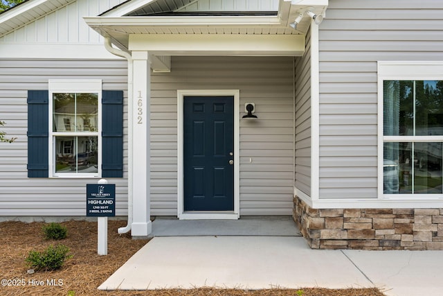 entrance to property with stone siding and board and batten siding