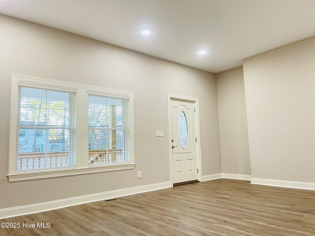 foyer with recessed lighting, visible vents, baseboards, and wood finished floors