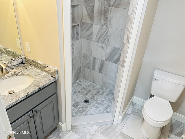 full bath featuring baseboards, toilet, marble finish floor, vanity, and a shower stall