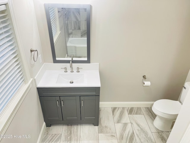 full bath featuring marble finish floor, vanity, toilet, and baseboards