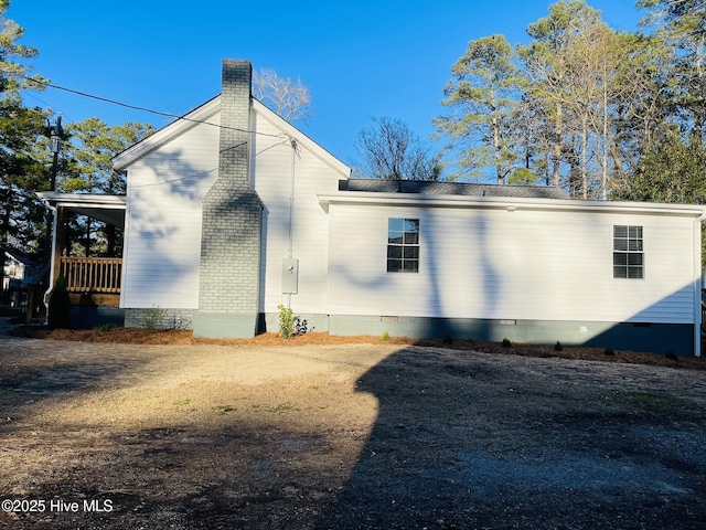 view of side of property featuring crawl space and a chimney