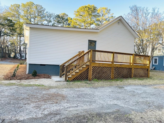 back of property featuring a deck, stairway, and crawl space