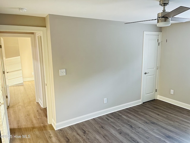 spare room with ceiling fan, baseboards, and wood finished floors