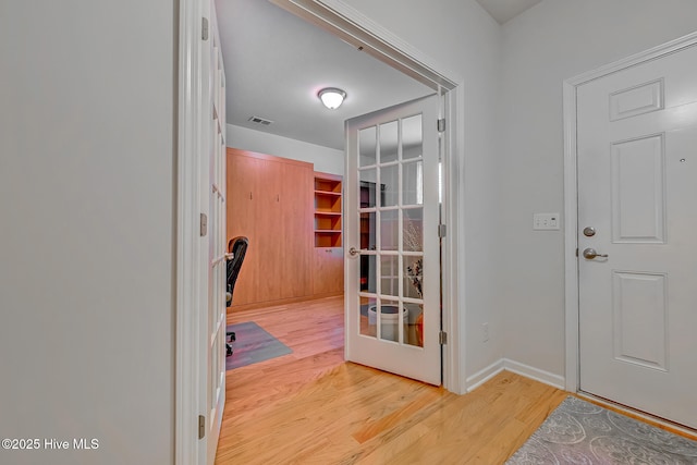 entryway featuring light wood-type flooring, french doors, visible vents, and baseboards